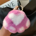 Close-up of heart-shaped rabbit fur keychain with pink and white plush texture - Purple