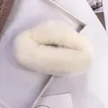 Detalle de una pinza para el pelo de piel sintética crema en una bandeja de exhibición - Blanco Roto