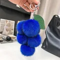 Détail d'un porte-clés grappe en fausse fourrure bleu roi avec feuilles vertes - Bleu foncé