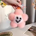 Detail of pink plush flower keychain with a smiling face and metal lobster clasp - Dusty Pink