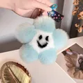 Close-up of blue and white plush flower keychain with smiling face and star tag - Lake Blue