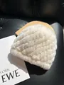 Detailed close-up of white plush hat with diamond quilt texture and faux rabbit fur - Off White