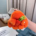 Detail eines flauschigen orangefarbenen Kaninchen Plüsch Anhängers mit goldenem Schlüsselring - Orange