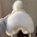 Dettaglio del cappello in maglia bianca con paraorecchie e pompon in morbida pelliccia - Taglia unica / Bianco