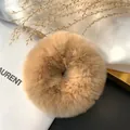 Macro shot of fluffy beige rabbit fur scrunchie with soft texture and chic design - Camel
