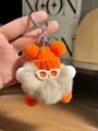 Gros plan d'un charme peluche mignon avec bonnet orange tricoté et anneau argenté - Orange Kaki