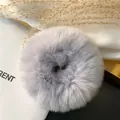 Close-up of soft lavender rex rabbit fur scrunchie on silk with dried flowers - Gray