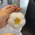Close-up of a plush flower keychain with white mink fur petals and a yellow center - Egg Yellow