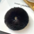Detailed view of a soft black rabbit fur scrunchie on a minimalist white background - Black