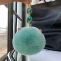 Detail of mint green plush rabbit fur keychain with pink cat ears and gold hardware - Green