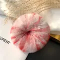 Detail of fluffy grey rex rabbit fur scrunchie with red marble texture on chic setup - Lovely Pink