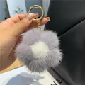Vue détaillée d'un porte-clés fleur en fourrure douce avec anneau en métal doré chic - Mauve Clair