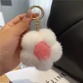 Détail d'un porte-clés fleur en peluche avec texture de vison sur un sac à main noir - Blanc Rose