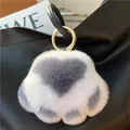 Close-up of fluffy white faux fur heart charm with grey center on a black handbag - White and Dark Gray