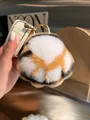 Close-up of fluffy tri-color rex rabbit fur cat paw keychain with a gold metal ring - Tiger Claw
