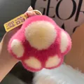 Nahaufnahme des rosa-weißen Plüsch-Katzenpfoten-Schlüsselanhängers mit Goldverschluss - Glücksbringer-Anhänger-Stil