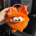 Schattige oranje pluizige monster sleutelhanger met geblokte strik en grote ogen - Oranjerood