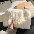 Close-up of a white faux fur pouch with elegant striped texture and soft plush feel - Off-White