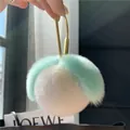 Close-up of fluffy mint green and ivory white fur ball keychain with golden U-shaped clasp - Mint Green and White (Water Drop Buckle)