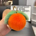 Detail of soft orange plush peach keychain with green leaves and golden metal ring clasp - Orange (Round Buckle)