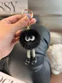 Close-up of black mink fur monster keychain with long woven legs and golden lobster clasp - Black
