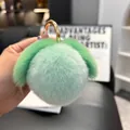 Close-up of a soft mint green rabbit fur peach keychain with gold metal ring - Mint Green (Round Buckle)
