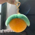 Detailansicht des Plüsch-Orangen-Anhängers mit weichem Kunstfell und Herz-Schlüsselanhänger - Orange und Grün Frucht (Herzschließe)