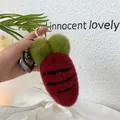 Close-up of plush carrot keychain with soft red faux fur and gold metal lobster clasp - Burgundy