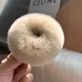 Dettaglio dell'elastico per capelli in pelliccia di coniglio beige con texture soffice - colore tè al latte