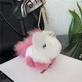 Detail of plush unicorn keychain with fluffy faux fur and a golden metal carabiner - Peach Pink