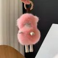 Close-up of pink mink fur sheep keychain with golden hardware and leather details - Light Pink