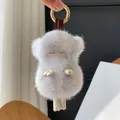 Dettaglio portachiavi a forma di pecora in pelliccia di visone con anello dorato lucido - Visone Incrociato