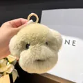 Gros plan d'un porte-clés peluche chiot beige duveteux avec une texture de fourrure douce - Couleur Thé au Lait