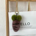 Rosa Plüsch-Karotten-Anhänger mit grünen Pompons und goldenem Ring an weißer Tasche - Kastanienbraun