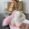 Close-up of plush unicorn pendant with soft fur, gold ring clip and pearl detail - Light Pink
