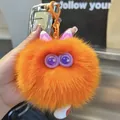 Detail eines süßen orangefarbenen Plüsch-Schlüsselanhängers mit flauschigen Ohren - Orange
