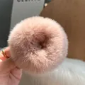 Dettaglio ravvicinato di un elastico per capelli in peluche rosa con morbida trama calda - Rosa Polvere