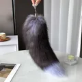 Pluffy faux fox tail charm in dark grey and lilac gradient on marble background - Dark Fox Blue Tint