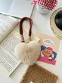 Macro detail of a beige plush heart keychain with soft faux fur and braided cord strap - Milk Tea