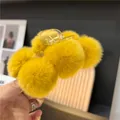 Detailed view of yellow faux fur ball hair claw clip with plush texture for winter - Ginger Yellow