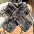 Détail de l'écharpe en fourrure de lapin gris foncé avec boucle croisée sur table - Gris clair