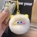 Cute fluffy rabbit fur monster keychain in beige with yellow ears and large cartoon eyes - Off White