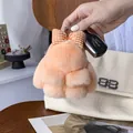 Dettaglio del portachiavi a forma di coniglio di peluche arancione con fiocco a quadri - Rosa carne