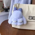 Portachiavi con coniglietto di peluche lavanda e fiocco a quadretti su borsa in pelle crema - Celeste