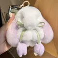 Cute white plush rabbit keychain with purple ears and green ribbon on a car key - Light Purple