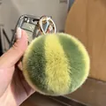 Pluizige konijnenbont sleutelhanger met groen-gele strepen aan een autosleutel - Watermeloen Ring Stijl
