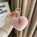 Dettaglio del portachiavi a cuore in pelliccia sintetica rosa con cinturino in pelle e fibbia - Rosa Carminio