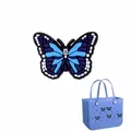Abalorio de mariposa azul y negra para bolso, mostrado en un bolso azul claro - Mariposa Azul Y Negra