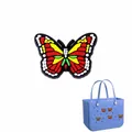 Abalorio de mariposa de PVC de colores en un bolso de mano azul de goma perforada - Mariposa Colorida