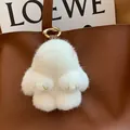 Plush white mink fur bunny keychain with golden metal clasp on a leather bag - White Leather Paws